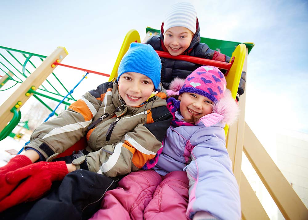 Kids playing on playground in winter clothes